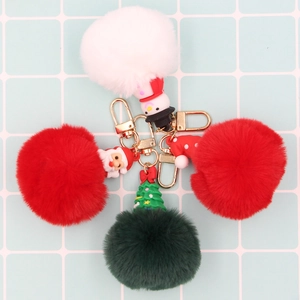 Three Christmas keychains with red white green plush balls and Santa snowman charms