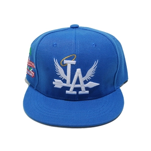 Detailansicht der blauen Snapback-Mütze mit weißem LA-Flügelstick und Seitenpatch