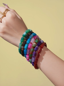 Nahaufnahme bunter gestreifter Naturstein-Perlenarmbänder am Handgelenk eines Models