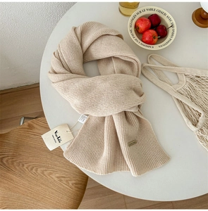 Close-up of premium 100% pure wool knitted scarf in beige showing soft texture