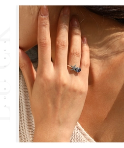 Detailed view of sterling silver starfish ring with blue stone on a model's finger