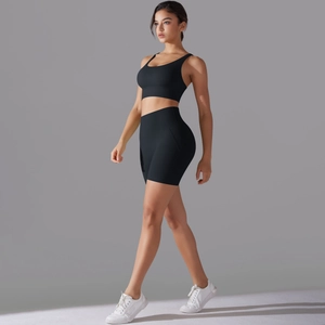 Vista laterale del set da yoga nero con reggiseno sportivo e pantaloncini a vita alta