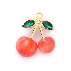 Detail of a red cherry pendant with gold stem and green crystal leaf on white background
