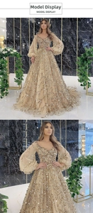 Details eines luxuriösen Abendkleides in Champagner-Gold mit Pailletten und Puffärmeln