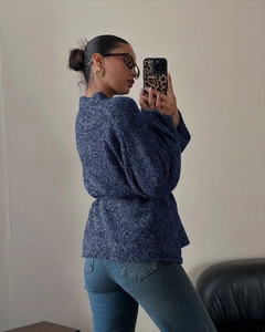 Texture dettagliata del cardigan in maglia blu scuro con maniche lunghe e vestibilità ampia