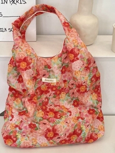 Floral print canvas tote bag with vibrant red and pink blossoms and sturdy shoulder straps