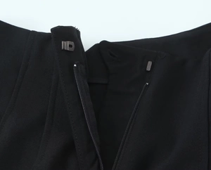 Dettaglio di cerniera invisibile e gancio metallico su pantaloncini neri eleganti