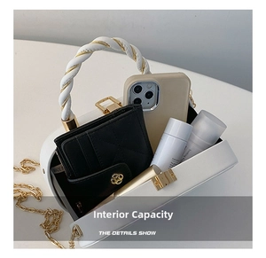 Macro view of white leather box bag interior showing phone, wallet and cosmetics capacity