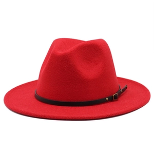 Dettaglio di un cappello fedora rosso con fascia in pelle nera e fibbia dorata
