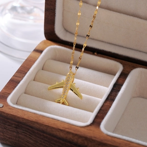 Elegant gold airplane pendant necklace with white zircon pavé in a walnut jewelry box