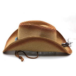 Detail of brown straw cowboy hat with turquoise beaded band and adjustable chin strap