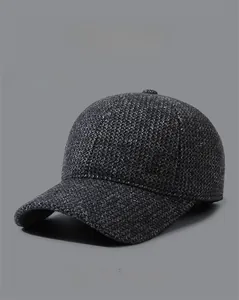 Detail of dark grey knit baseball cap for elderly men showing thick wool texture and side logo