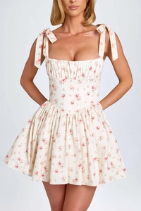 Close-up of square neckline with adjustable bow tie straps and pink floral pattern