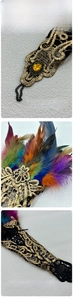 Detail view of gothic lace arm cuffs with colorful feathers and yellow gemstone inlay