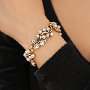 Close-up of vintage gold bracelet with oval pearls and sparkling crystals on wrist
