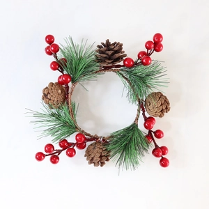 Makroaufnahme von Weihnachtskerzenring mit roten Beeren, Tannennadeln und Zapfen