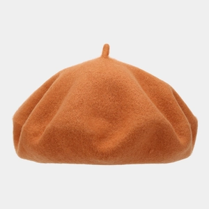 Detailed texture of caramel wool felt beret featuring classic top stem decoration