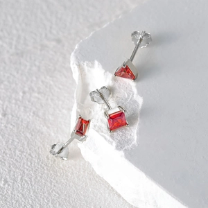 Detailed macro view of S925 sterling silver studs with red ruby geometric shaped gems