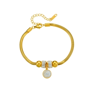Golden snake chain bracelet with crystal charm and round metal beads on white background