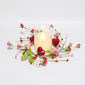 Valentine candle ring with red pink hearts berries and lighted candle in glass jar