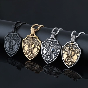 Close-up of Archangel Michael shield pendants in black, gold, and silver stainless steel