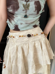 Detail of bohemian waist chain with wooden beads and turquoise butterfly pendant