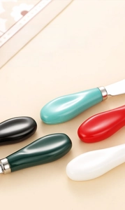 Dettaglio di coltelli da burro con manici colorati in ceramica e lame in acciaio inossidabile