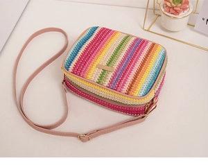 Macro detail of colorful striped woven texture and pink leather strap on straw bag