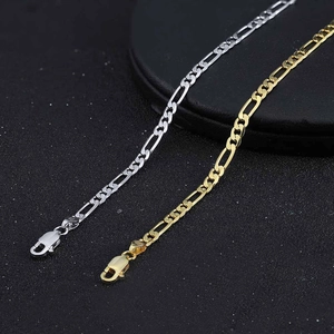 Detail view of 5mm Figaro chain bracelets in gold and silver finishes on a matte background