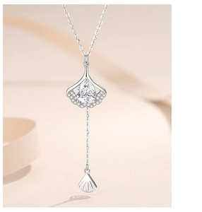 Detailed view of silver ginkgo leaf necklace pendant with tassel and micro-set zircon