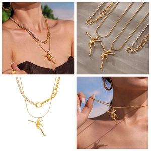 Detail of layered gold necklace featuring a dancing girl pendant and zircon tennis chain