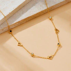 Elegant gold stainless steel necklace with heart pendants and crystal accents on stone