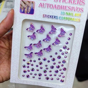 Detail of purple 3D butterfly nail art stickers and round rhinestones in packaging