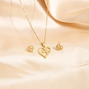 Golden stainless steel heart jewelry set with heartbeat patterns on beige silk cloth