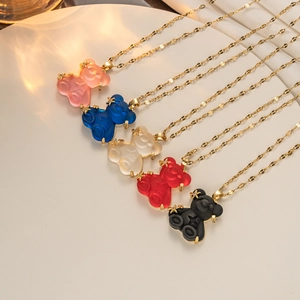 Close-up of five colorful resin bear necklaces with gold chains in professional still life setup