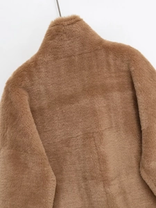 Detail shot of the plush camel faux fur texture on the high collar and back of the jacket
