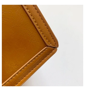 Detail der braunen Leder-Umhängetasche mit präzisen Nähten und feiner Kieselstruktur
