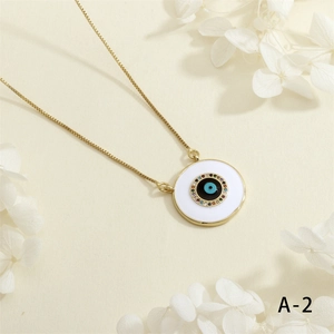 Detailed macro shot of a gold Evil Eye pendant with colorful zircons and white enamel