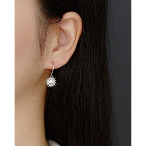 Close-up of S925 sterling silver sun flower earrings with clear zircon on female model