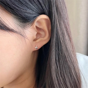 Close-up of minimalist S925 silver star stud earring worn on a model's ear lobe