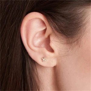 Golden marquise sun star stud earring shown on ear with sparkling zircon stones