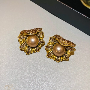 Gros plan de boucles d'oreilles vintage en coquillage avec strass et perles champagne