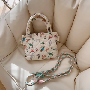 Detailed macro view of quilted floral cotton phone bag with woven shoulder strap and metal hooks