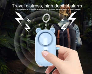 Close-up of portable blue bear-shaped safety alarm with sound wave effects for women