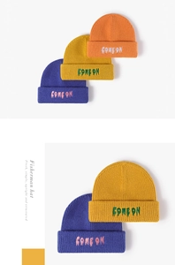 Detail of three colorful knitted beanies featuring Come On letter embroidery on thick wool