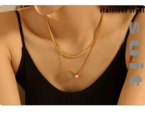 Close-up of double-layer stainless steel gold necklace with colorful enamel heart pendant