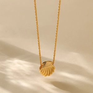 Vertical view of 18K gold plated necklace with a shell pendant on a warm background