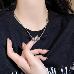 Close-up of sparkling cylinder pendant necklace on model with minimalist design
