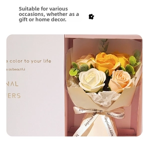Detail showing artificial soap roses in white and yellow colors inside a pink gift box