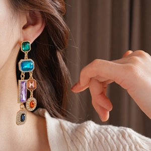 Details von luxuriösen Vintage-Ohrhängern mit bunten Kristallen an einem Model
